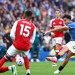 Jogador do Brighton finaliza cercado por Gabriel Magalhães e Ezri Konsa, do Arsenal, durante Brighton 3 x 0 Arsenal pela Premier League 2026/27