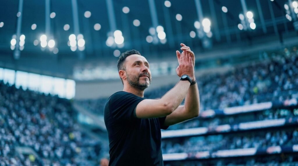 Técnico Roberto De Zérbi do Tottenham aplaudindo com arquibancadas lotadas de fundo