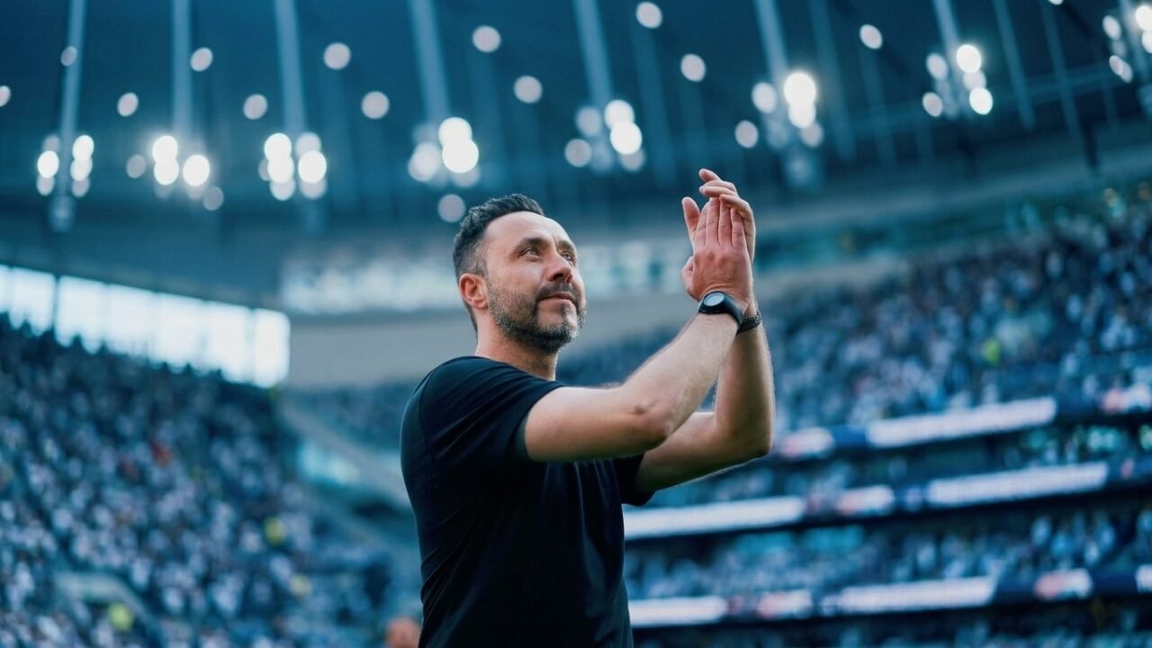 Técnico Roberto De Zérbi do Tottenham aplaudindo com arquibancadas lotadas de fundo