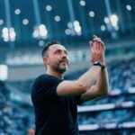 Técnico Roberto De Zérbi do Tottenham aplaudindo com arquibancadas lotadas de fundo