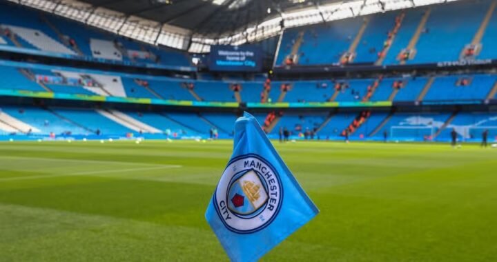 Bandeirinha de escanteio com o escudo do Manchester City no gramado do Etihad Stadium